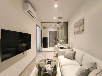 Modern living room with sleek design, featuring a cozy sofa, wall-mounted TV, and elegant decor.