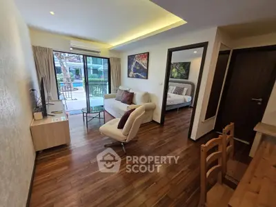 Modern living room with wooden flooring and open view to bedroom and balcony.
