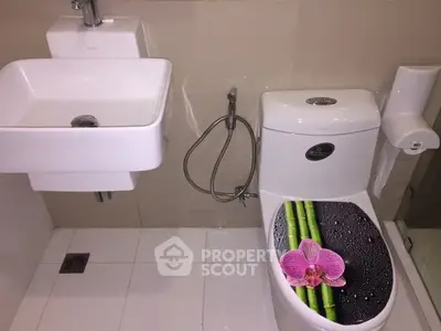 Modern bathroom with sleek fixtures and decorative toilet seat cover.