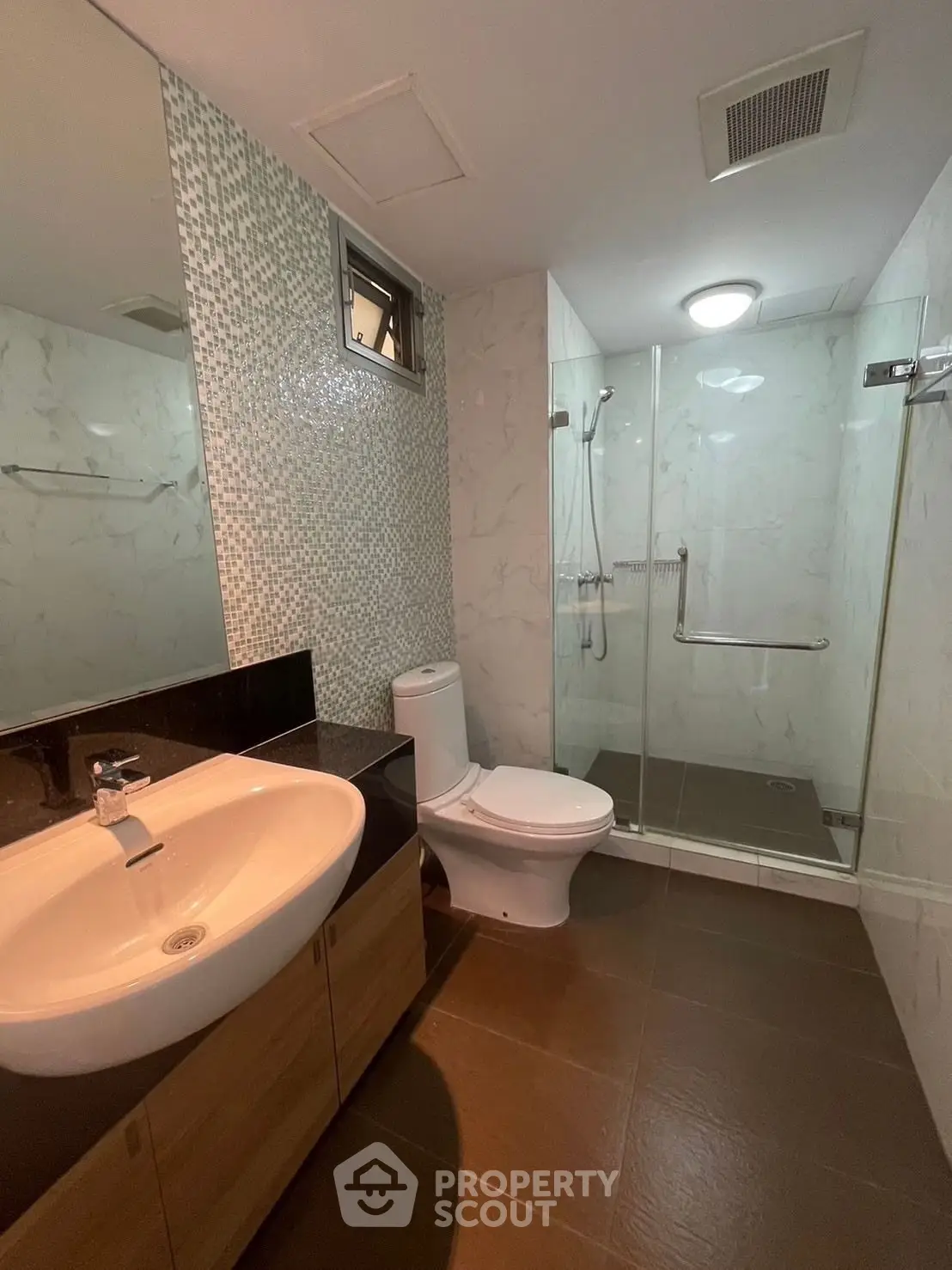 Modern bathroom with glass shower and stylish vanity in a contemporary apartment.
