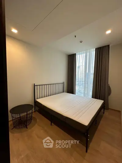 Modern bedroom with minimalist design and large window offering city view