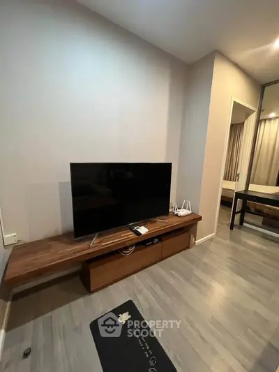 Modern living room with sleek TV setup and wooden flooring