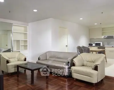 Spacious living room with modern furniture and open kitchen layout in a stylish apartment.