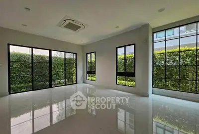 Spacious modern living room with large windows and garden view, perfect for natural light lovers.