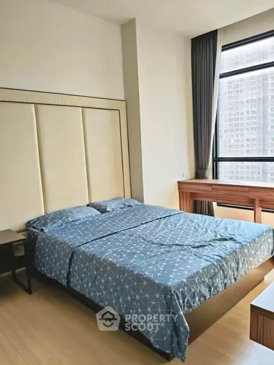 Modern bedroom with large window and stylish decor in urban apartment