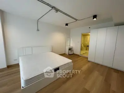 Spacious modern bedroom with minimalist design and wooden flooring