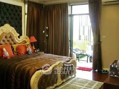 Luxurious bedroom with ornate bed and access to private balcony