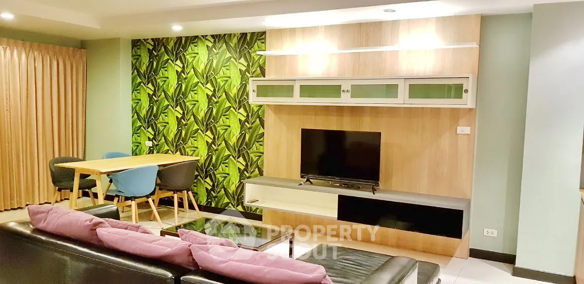 Stylish living room with modern decor, vibrant green accent wall, and cozy seating area.