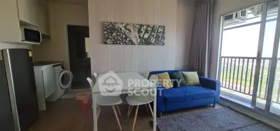 Modern living room with blue sofa, dining table, and balcony view in a stylish apartment.