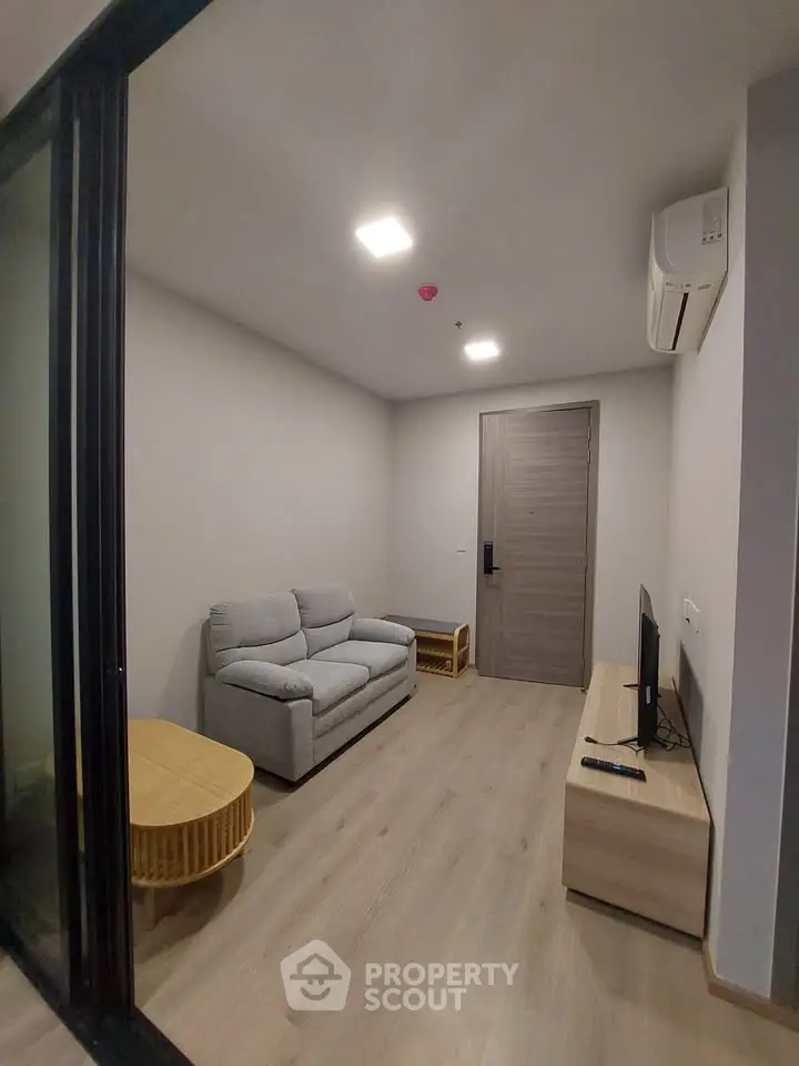 Modern living room with cozy sofa, TV, and air conditioning