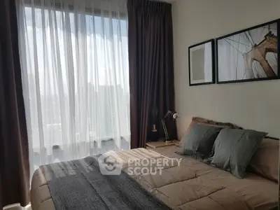 Cozy bedroom with large window and stylish decor in modern apartment