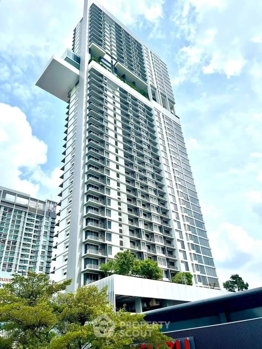 Stunning modern high-rise building with lush greenery and sky garden, offering luxurious urban living.