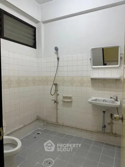 Minimalist bathroom with shower and sink in tiled interior