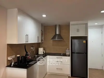 Modern kitchen with sleek cabinets and stainless steel appliances in a cozy apartment.