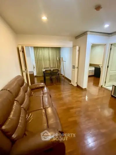 Spacious living room with wooden flooring and leather sofa in modern apartment