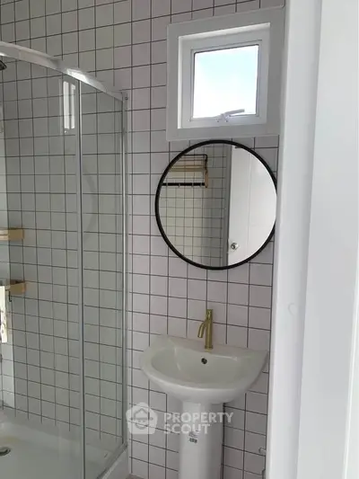 Modern bathroom with sleek shower and stylish round mirror