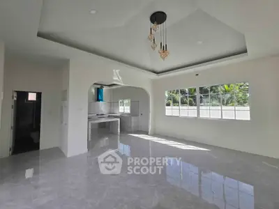 Spacious open-plan living area with modern kitchen and large windows