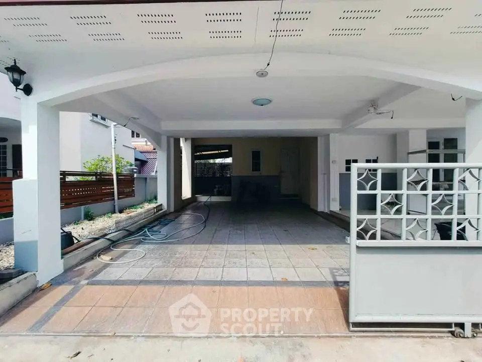 Spacious covered parking area in modern residential property with tiled flooring.