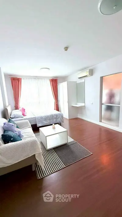 Spacious bedroom with twin beds, large window, and modern decor in a bright apartment.
