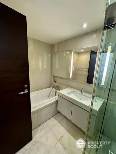 Modern bathroom with sleek design, featuring a bathtub and stylish vanity in a contemporary apartment.