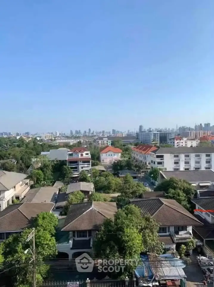 Stunning aerial view of suburban homes with lush greenery and city skyline in the background.