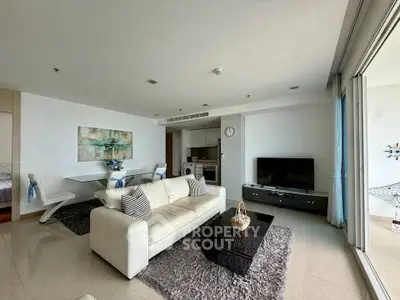 Spacious modern living room with elegant decor and open layout, featuring a cozy sofa and large TV.