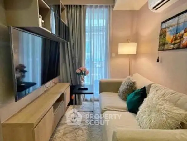 Cozy living room with modern decor, plush sofa, and large TV, perfect for relaxation.