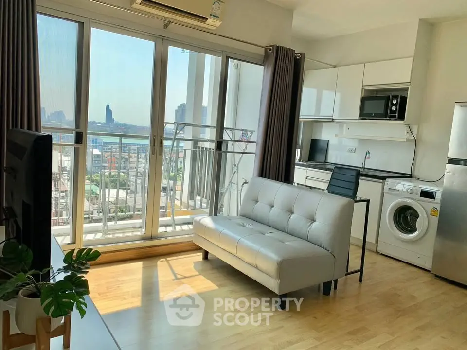 Modern living room with balcony view, sleek kitchen, and stylish furniture in a high-rise apartment.