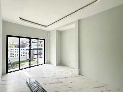 Spacious modern living room with large windows and elegant marble flooring.