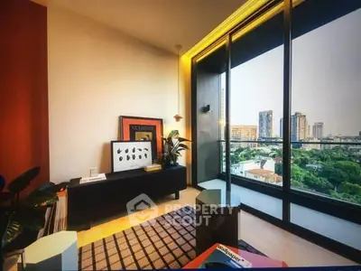 Modern living room with large windows offering stunning city views and stylish decor.