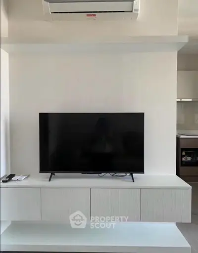 Modern living room with sleek TV setup and air conditioning unit, perfect for comfortable living.