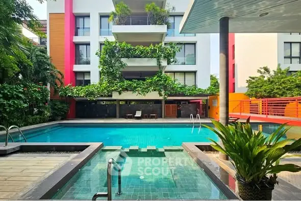 Luxurious residential building with a stunning pool and lush greenery, perfect for relaxation and leisure.