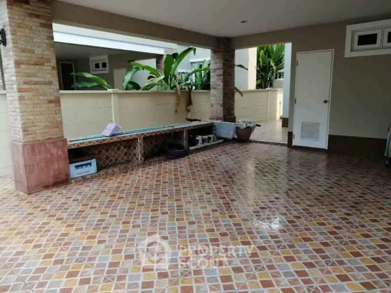 Spacious tiled patio area with garden view and storage bench.