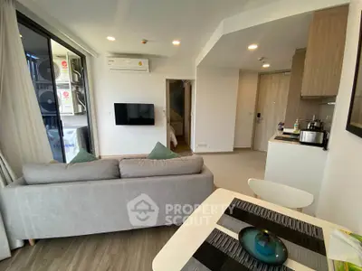 Modern open-plan living room with cozy sofa and dining area in a stylish apartment.