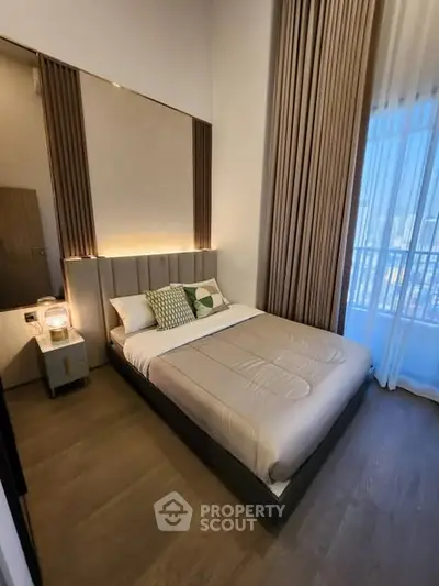 Modern bedroom with elegant decor and floor-to-ceiling windows offering city views.