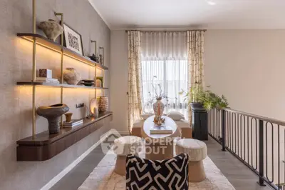 Stylish living room with modern decor and elegant shelving, featuring natural light and cozy seating area.