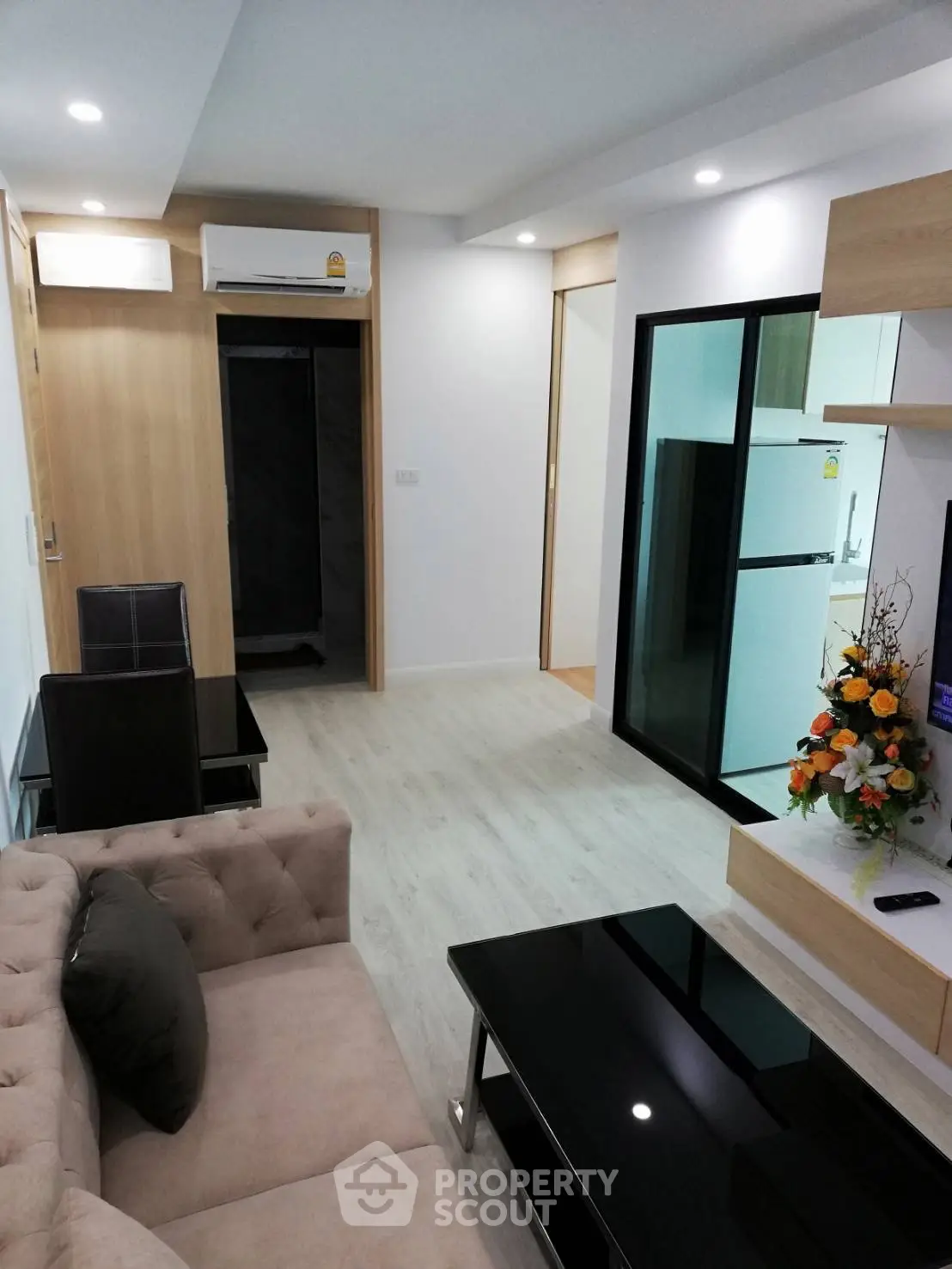 Modern living room with stylish furniture and open layout, featuring a sleek kitchen area and elegant decor.