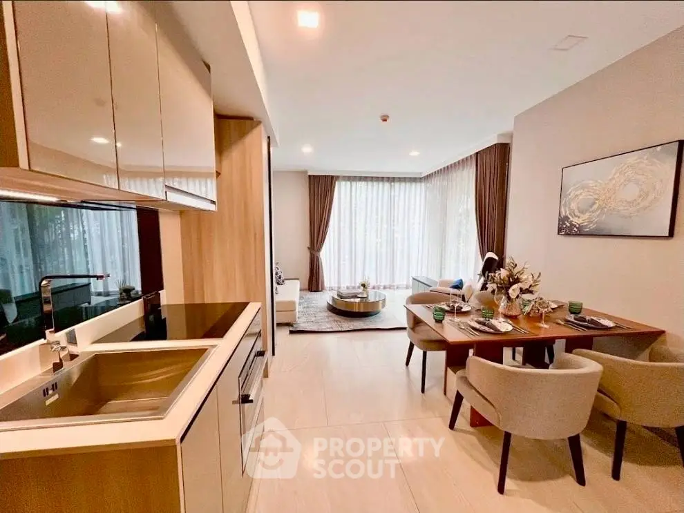 Modern open-layout kitchen and living room with elegant dining area and natural light.
