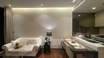 Modern living room with elegant sofa and open kitchen layout, perfect for cozy gatherings.