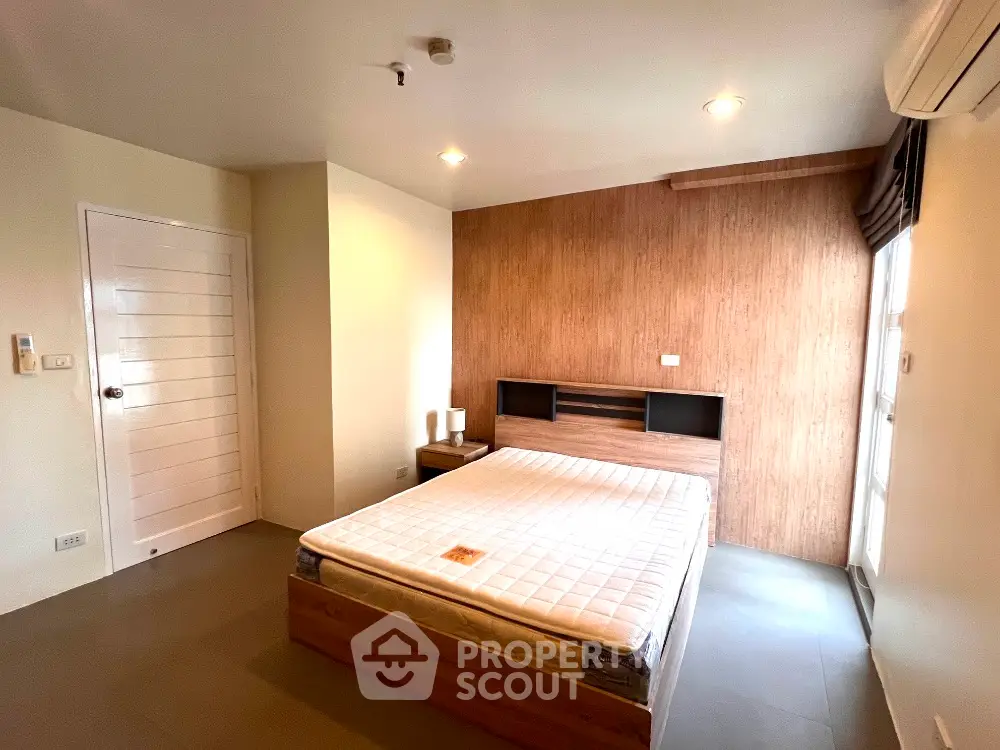 Modern minimalist bedroom with wooden accents and natural light