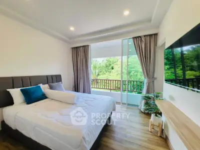 Spacious bedroom with large window and lush garden view, featuring modern decor and cozy ambiance.