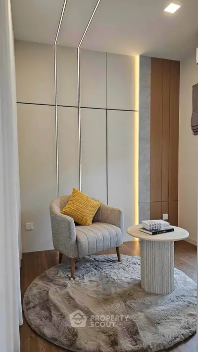Modern cozy reading nook with stylish armchair and round table on plush rug