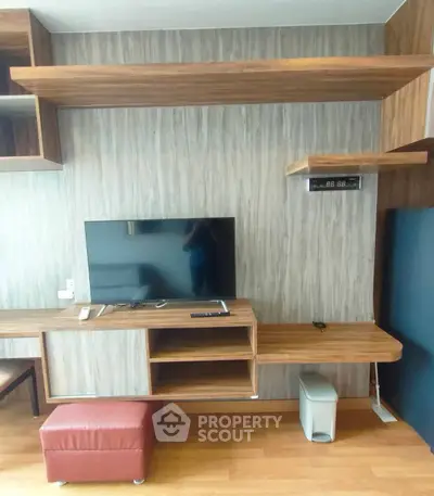Modern living room with stylish wooden shelves and mounted TV, perfect for contemporary living.