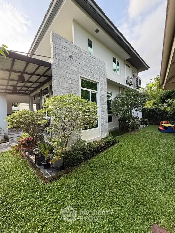 Modern two-story house with lush garden and stone facade
