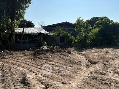 Rustic rural property with potential for development, surrounded by lush greenery and open land.