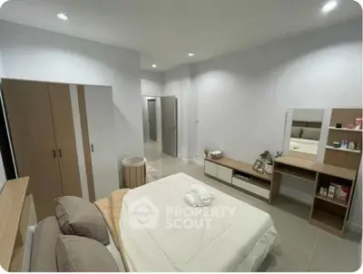 Spacious modern bedroom with sleek furniture and neutral tones