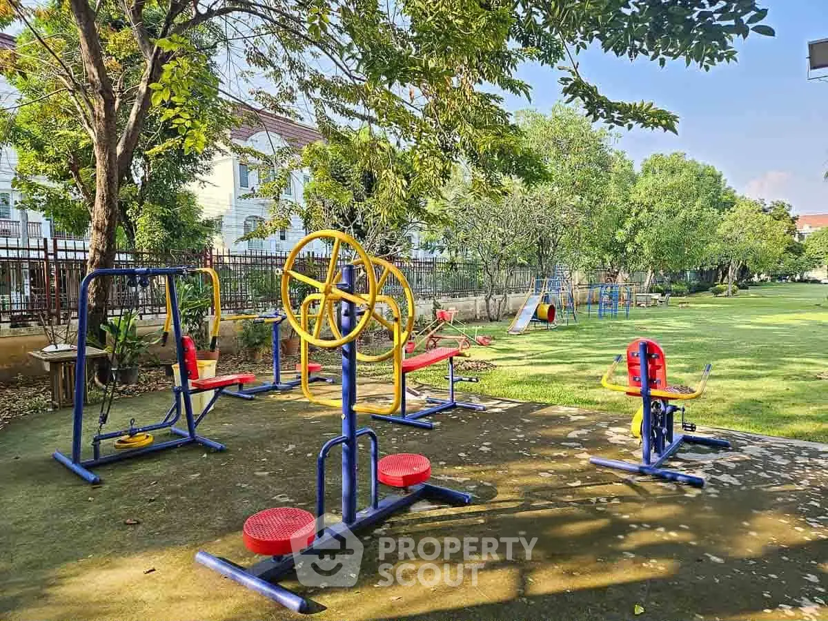 Charming outdoor playground area in a residential community with exercise equipment and lush greenery.