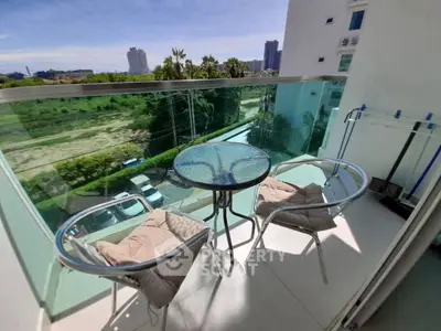 Charming balcony with glass railing and city view, perfect for relaxing outdoors.