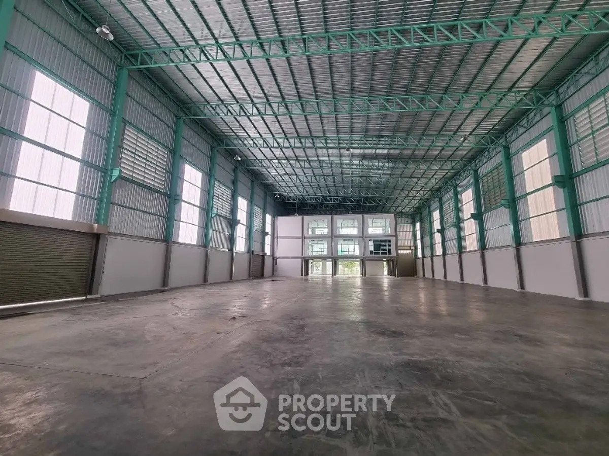 Spacious industrial warehouse with high ceilings and ample natural light.