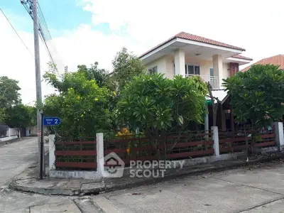 Charming two-story house with lush garden on a corner lot in a serene neighborhood.